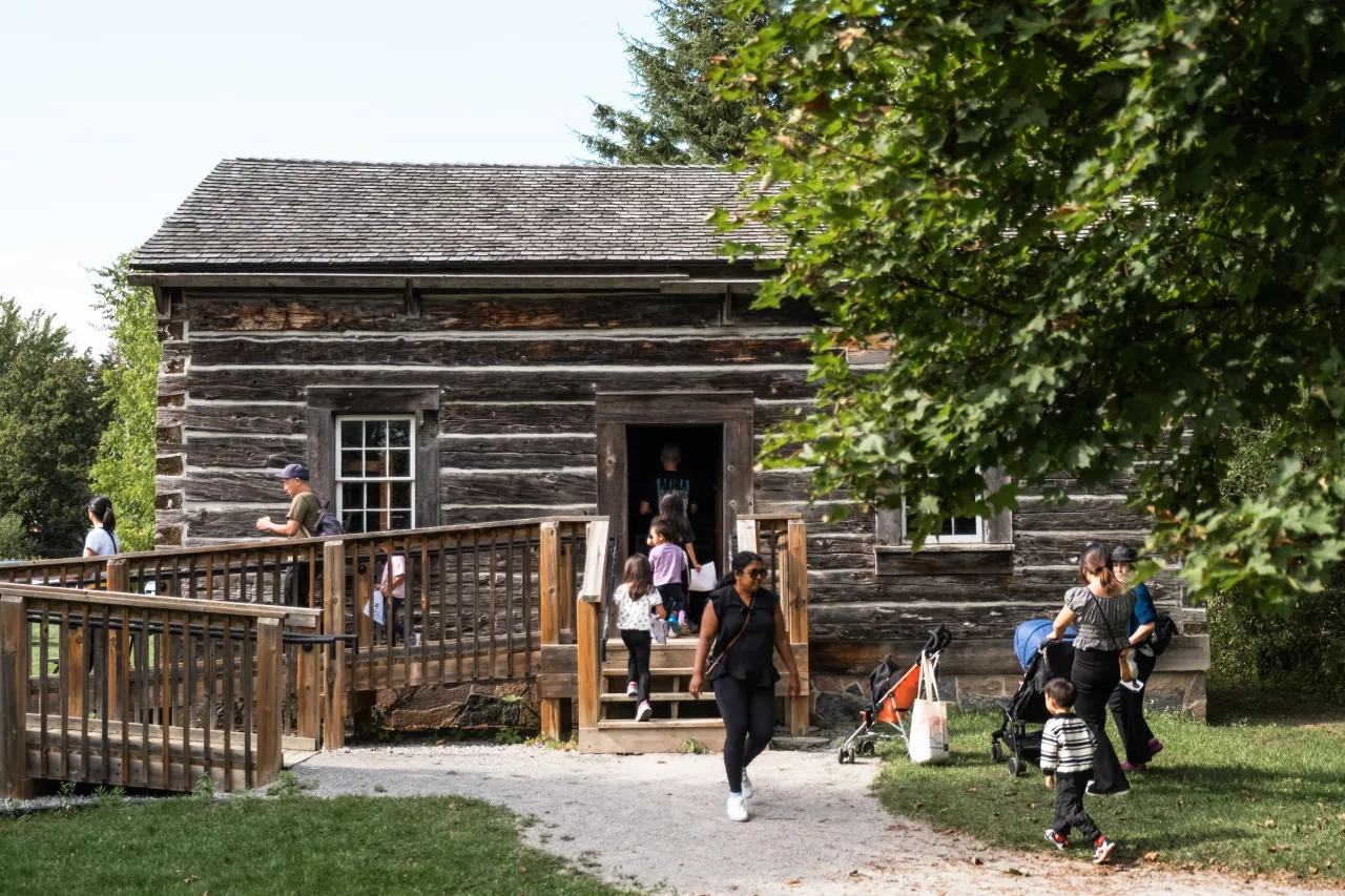 People walking in and out of a wooden building.