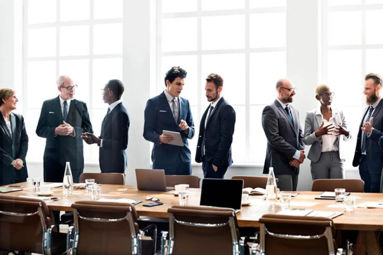 Business people talking around a table.