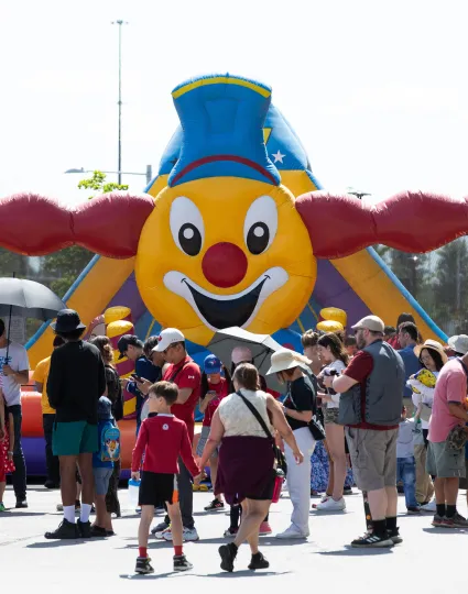 Crowd around inflatable park.