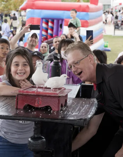 Children watching magic act on a stage.