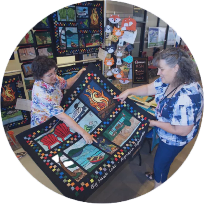 two people discussing a hand made quilt