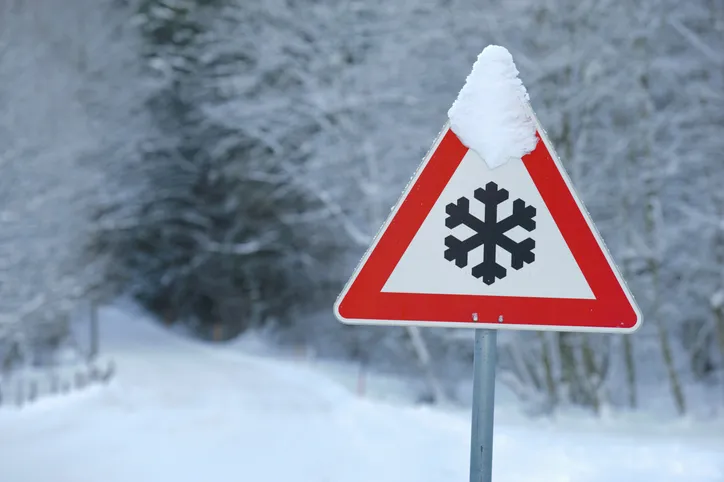 Traffic warning sign of ice and snow on road