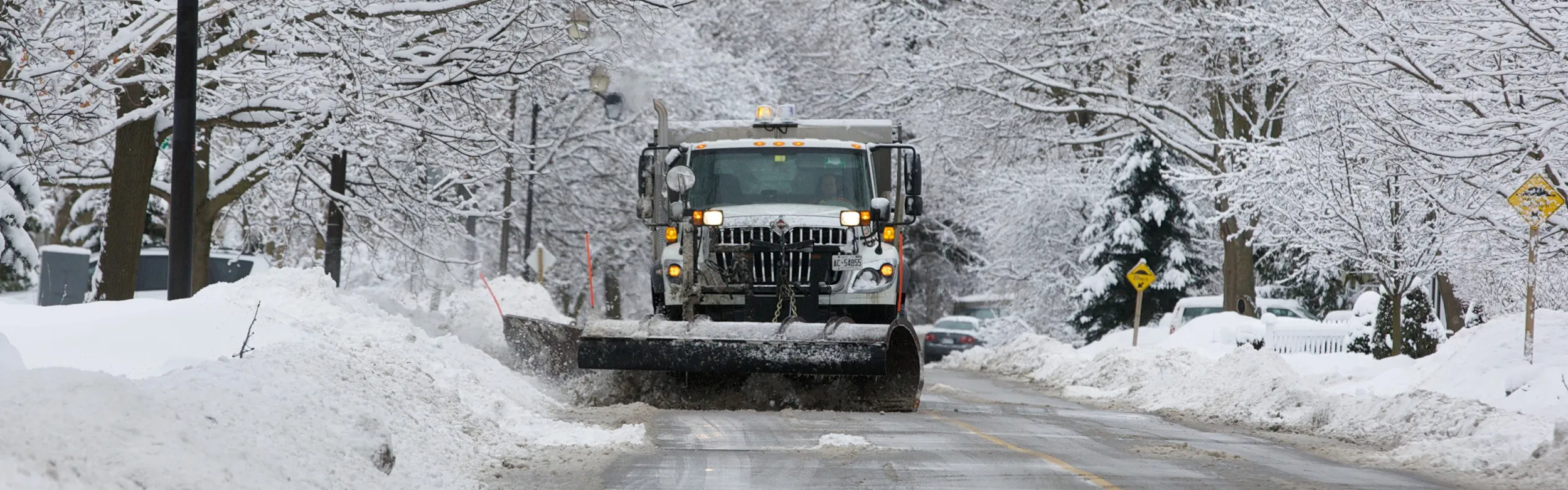 Markham snow plow clearing snow from a road in a snow covered neighbourhood.